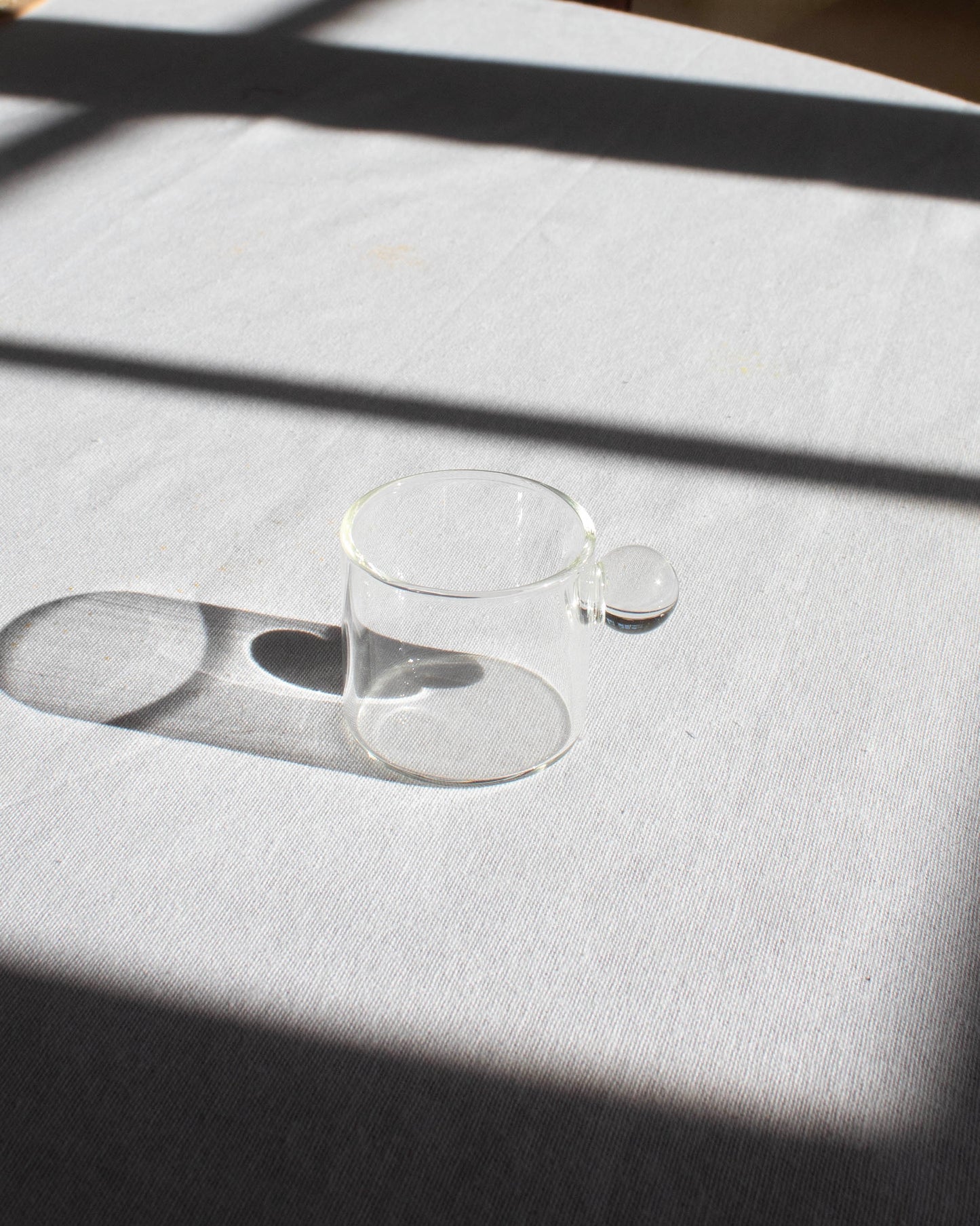 Elegant clear glass cup with a minimalist design for hot and cold drinks.