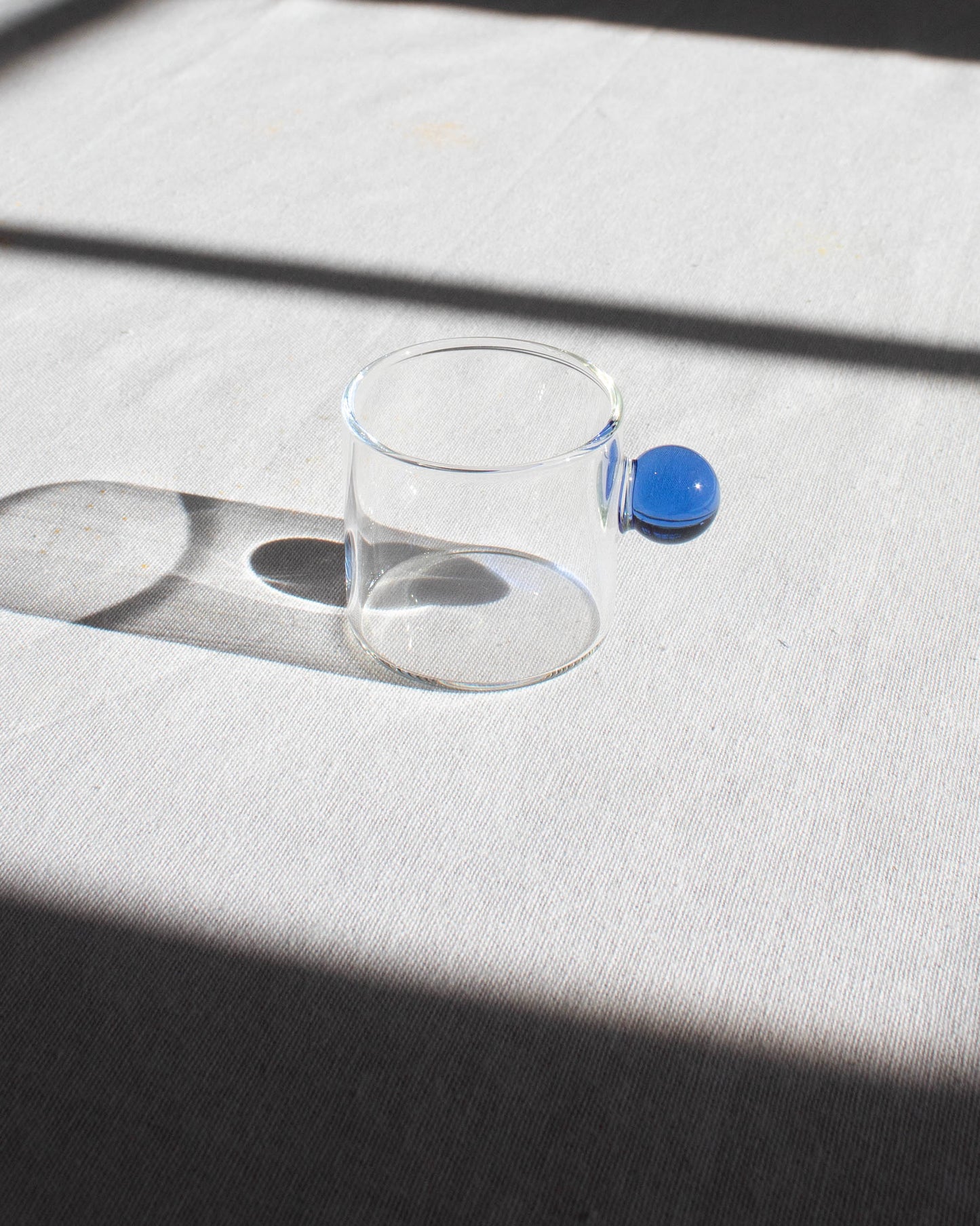 Elegant clear glass cup with a minimalist design for hot and cold drinks.