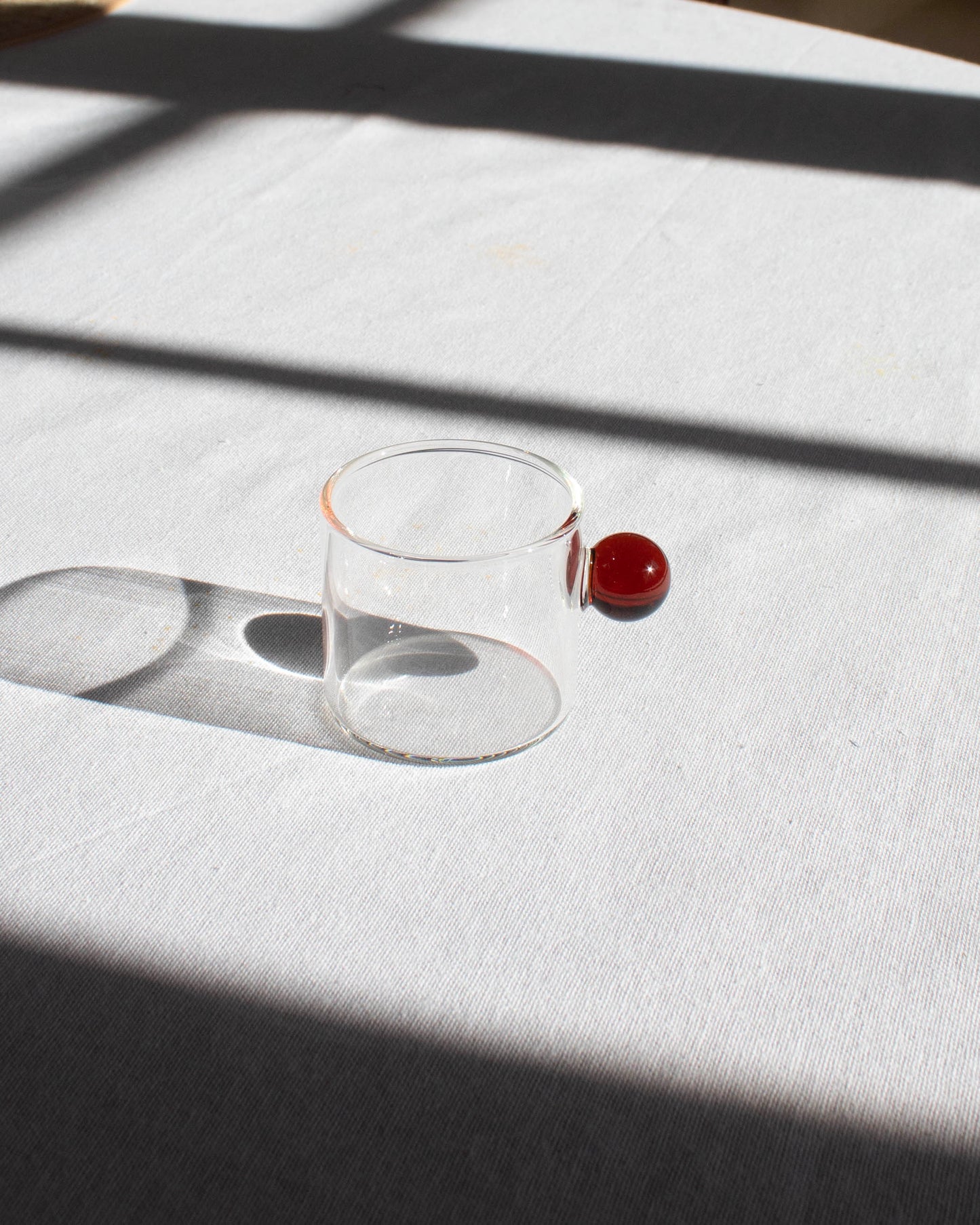 Elegant clear glass cup with a minimalist design for hot and cold drinks.
