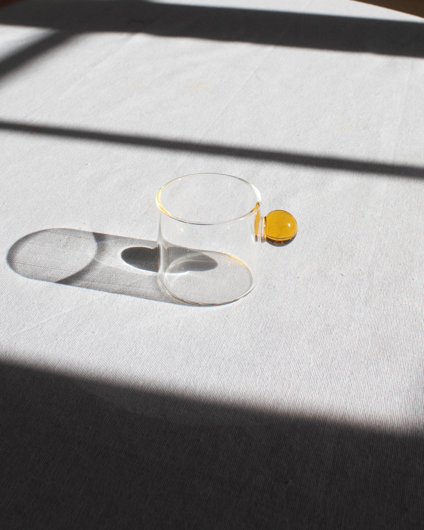 Elegant clear glass cup with a minimalist design for hot and cold drinks.