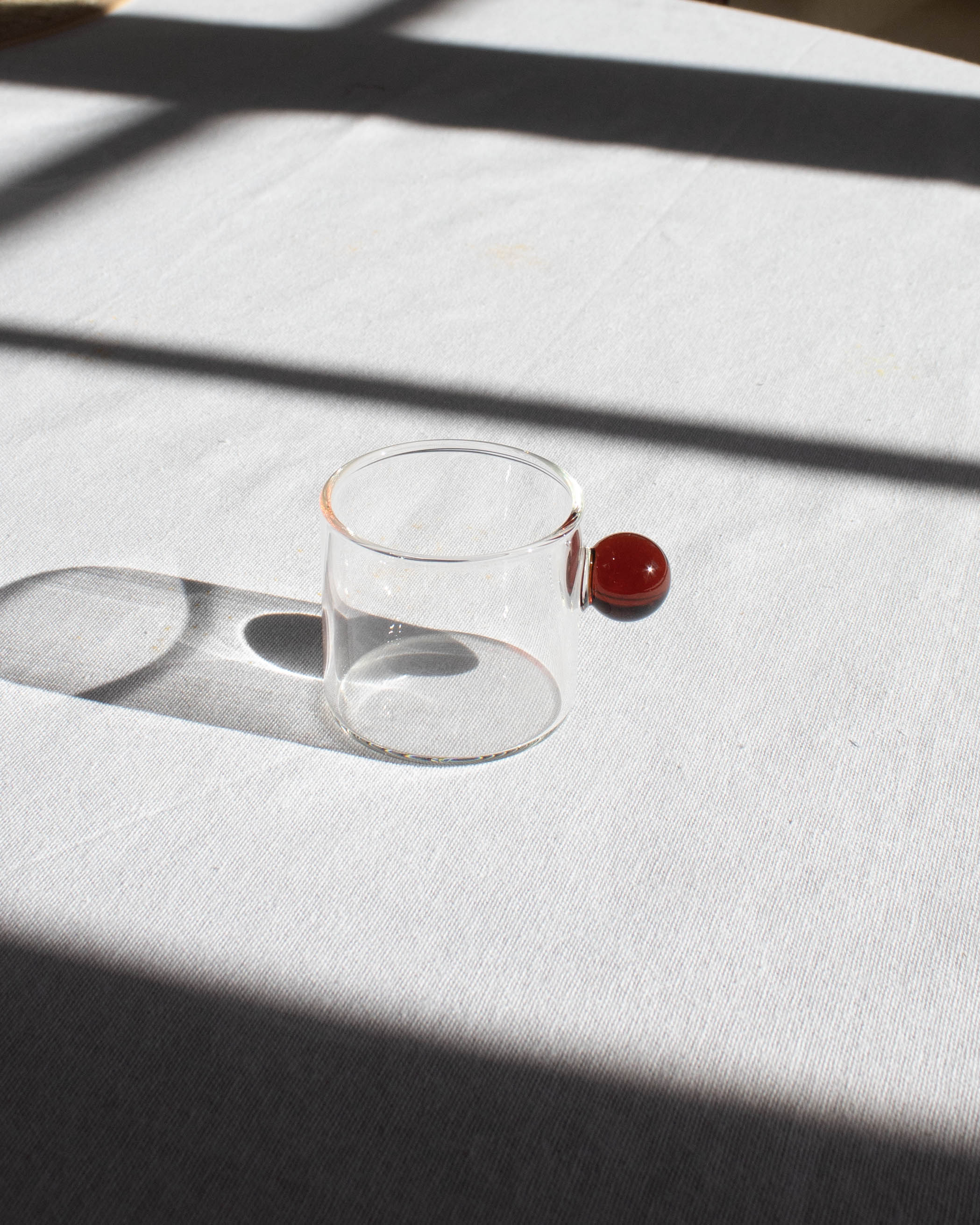 Elegant clear glass cup with a minimalist design for hot and cold drinks.